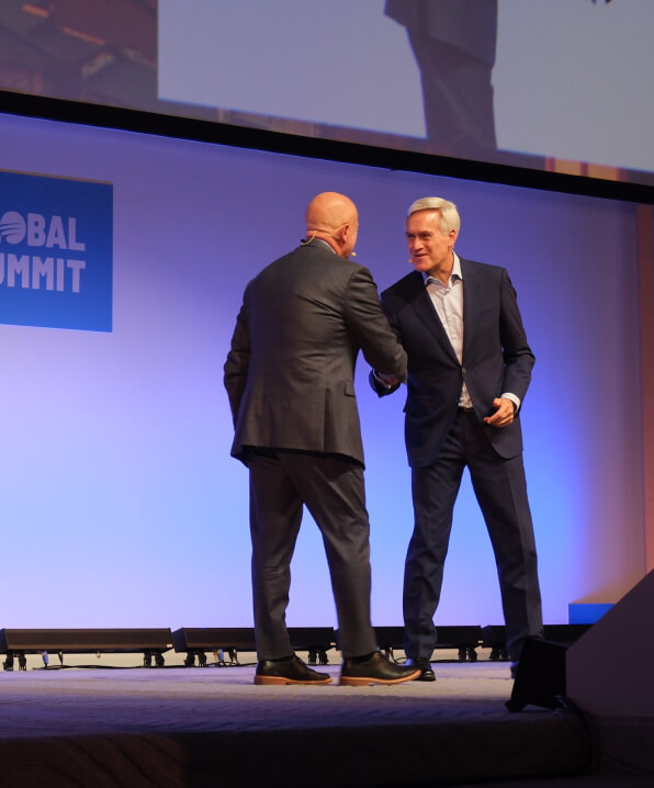 a photo of two men on stage shaking hands